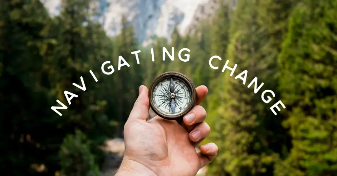 hand with compass on wooded background with text "navigating change"