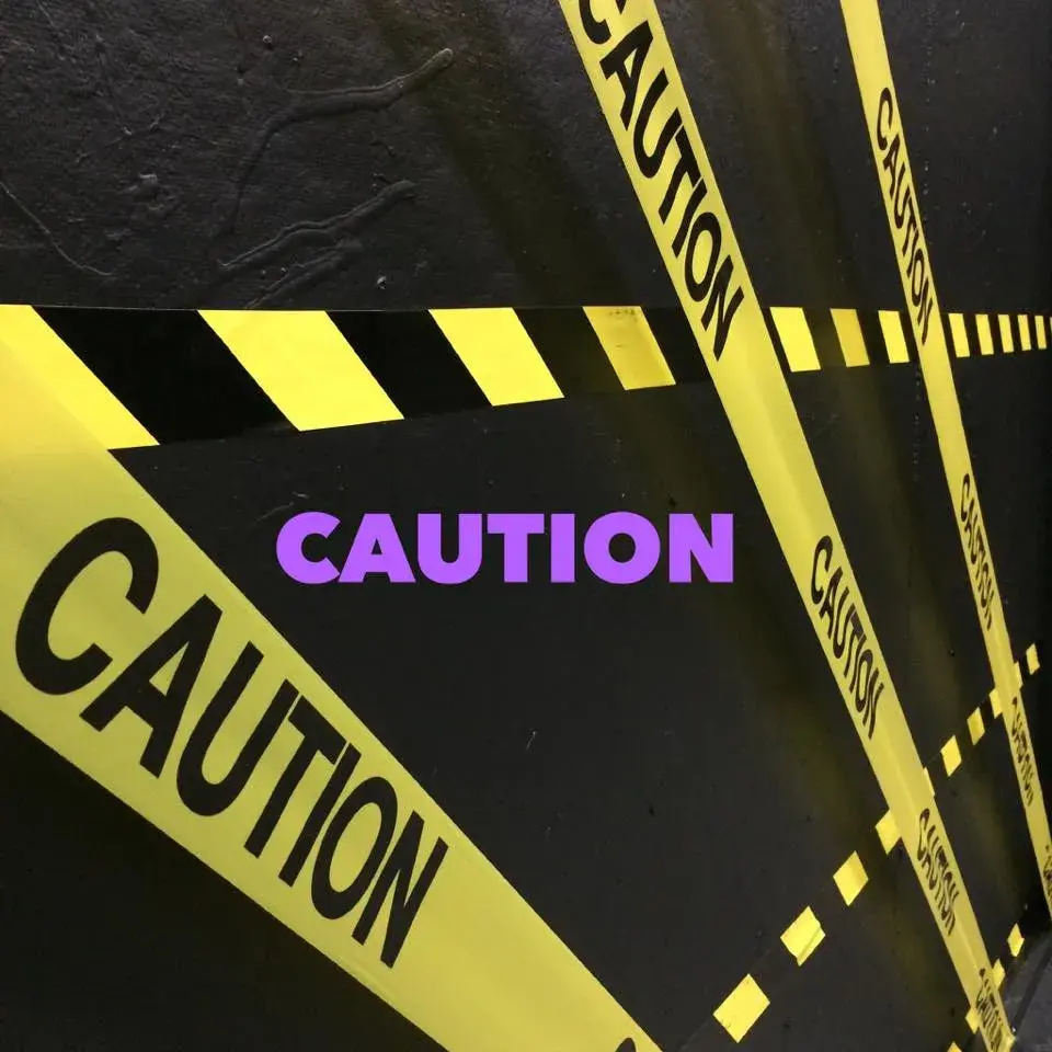 caution tape on black background with "caution" in purple 