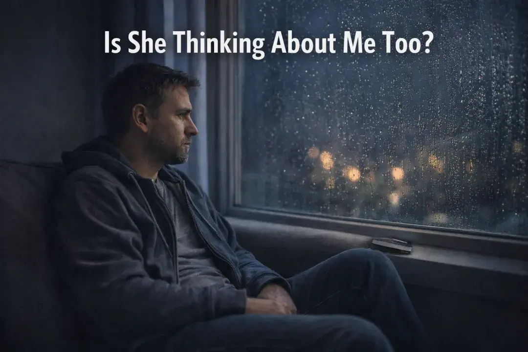 Man sitting alone by a window wondering if a woman is thinking about him after a breakup