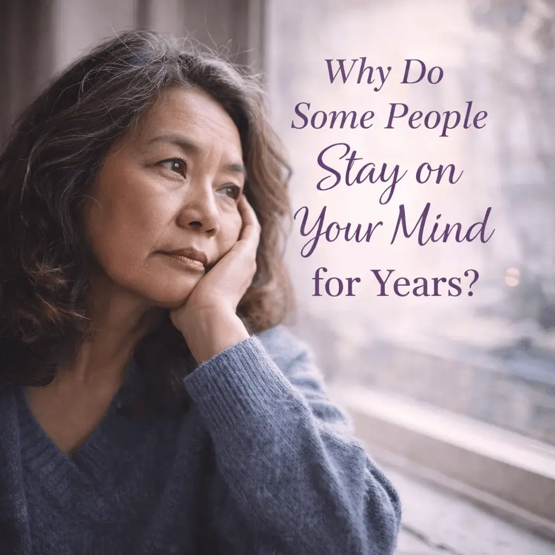 Woman thoughtfully looking out a window reflecting on why someone stays on your mind for years