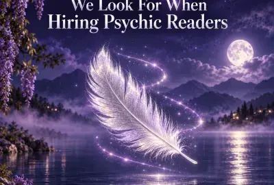 A glowing white feather drifting over a moonlit lake framed by wisteria, representing the gifts of a psychic reader
