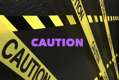 caution tape on black background with "caution" in purple