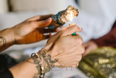 Woman lighting sage with lighter for ceremony